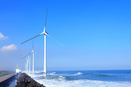 沖合いで発電している、風車の形をした発電装置「ウインドパワーかみす」の写真
